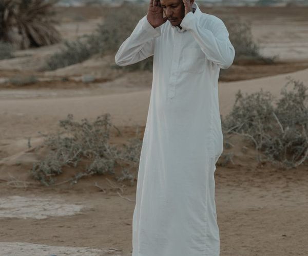 A serene landscape with a person meditating at sunrise.